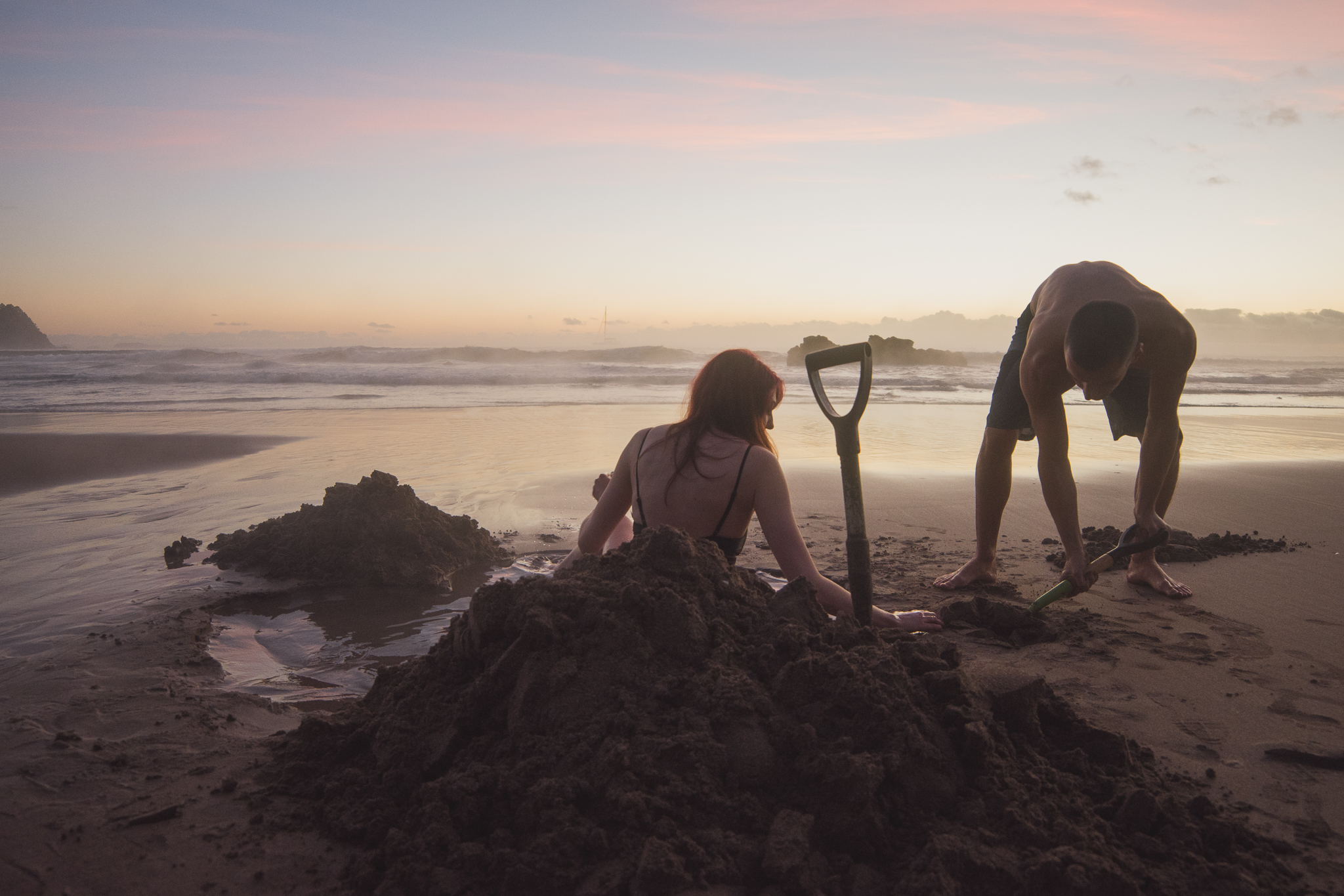 Digging holes on Hot Water Beach at sunrise